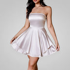 Woman wearing a strapless satin dress against a plain background